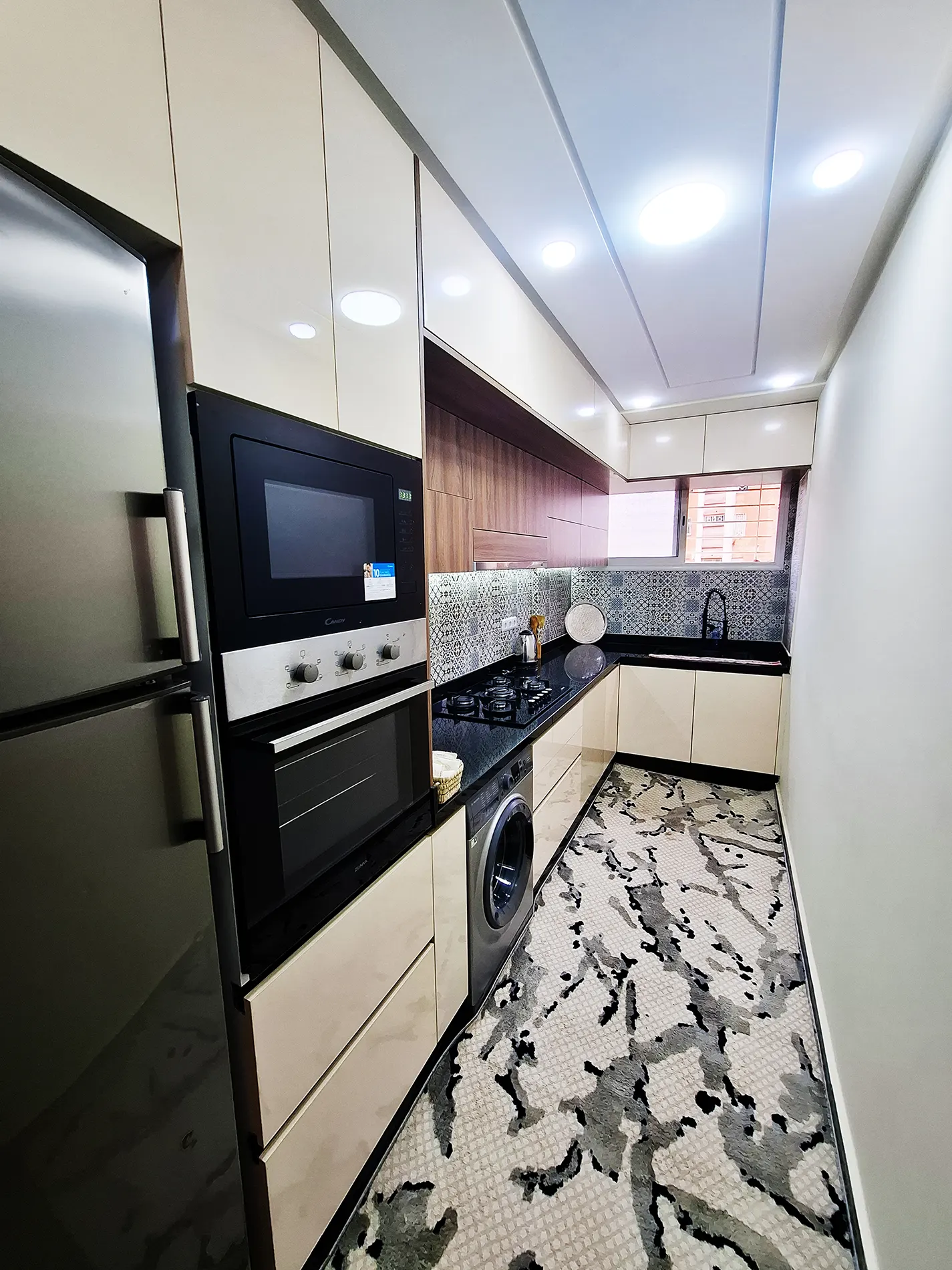 Modern kitchen with oven, hob and washing machine.