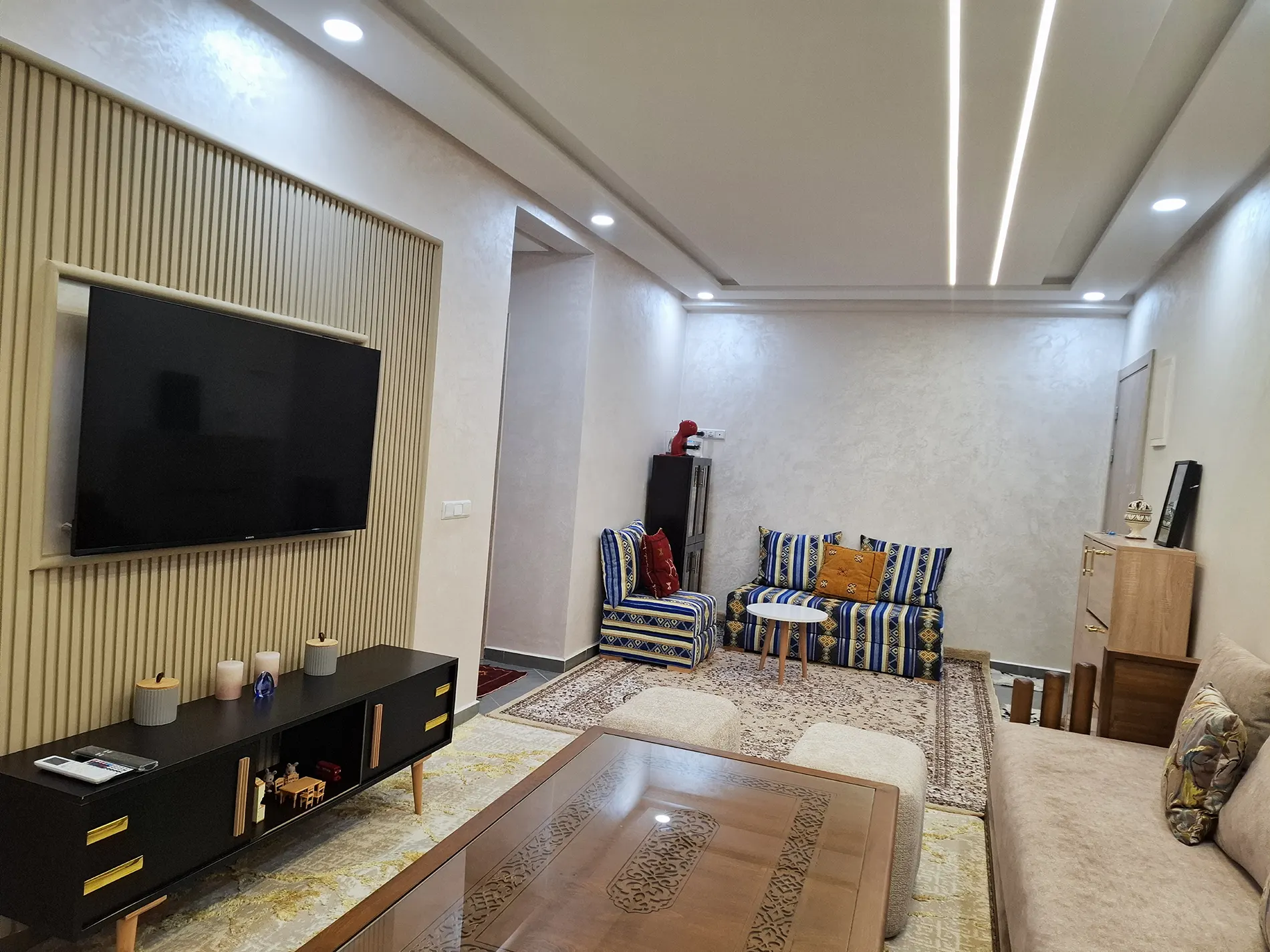 Wide living room view with seating and TV.