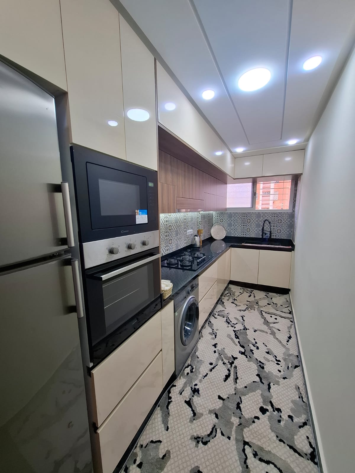 Modern kitchen with oven, hob and washing machine.