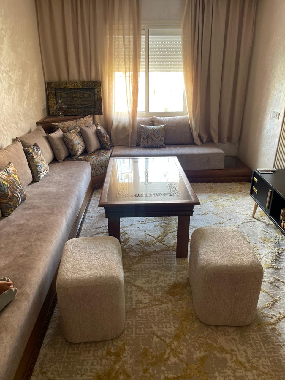 Living room with natural light and large coffee table.